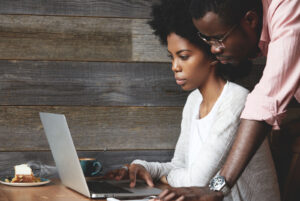 man and woman browsing on a laptop