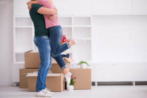 couple hugging in front of packing boxes