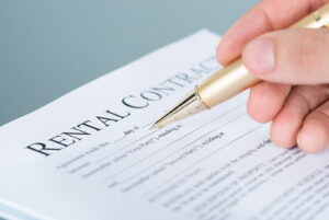 person signing a rental contract