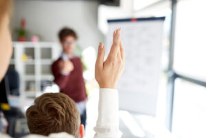 woman raising her hand to ask a question
