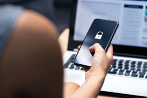 Woman working on a laptop and cell phone simultaneously