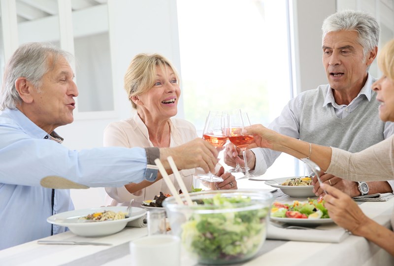 four baby boomers socializing around table