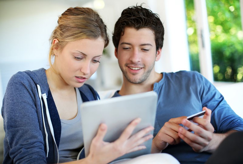 couple searching for homes on a tablet computer