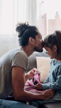 Father kisses daughter on forehead